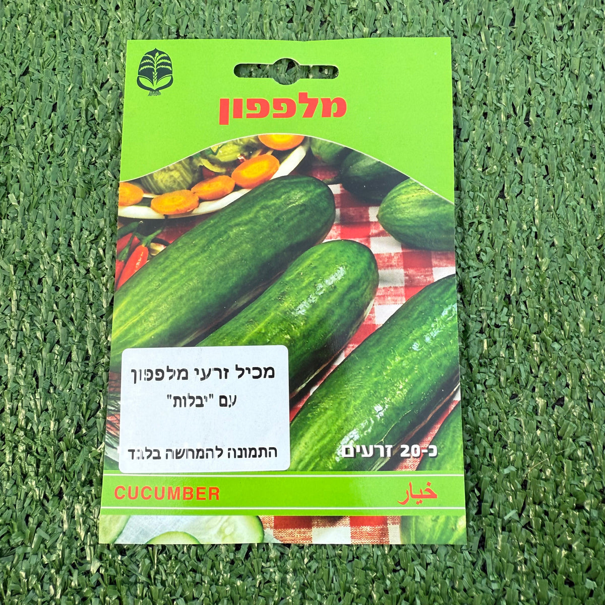 חפיסת זרעי מלפפון ברקע של דשא סינטטי ירוק