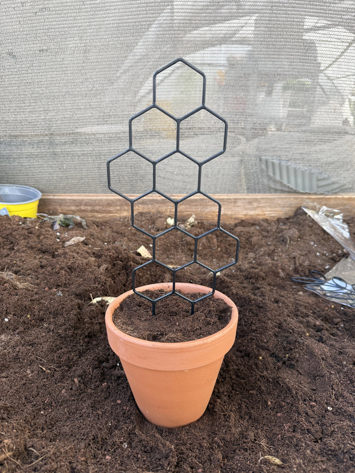 גדר פלסטיק שחורה למטפסים בדוגמת כוורת, 30×13 ס״מ, בהדגמת נעיצה בעציץ