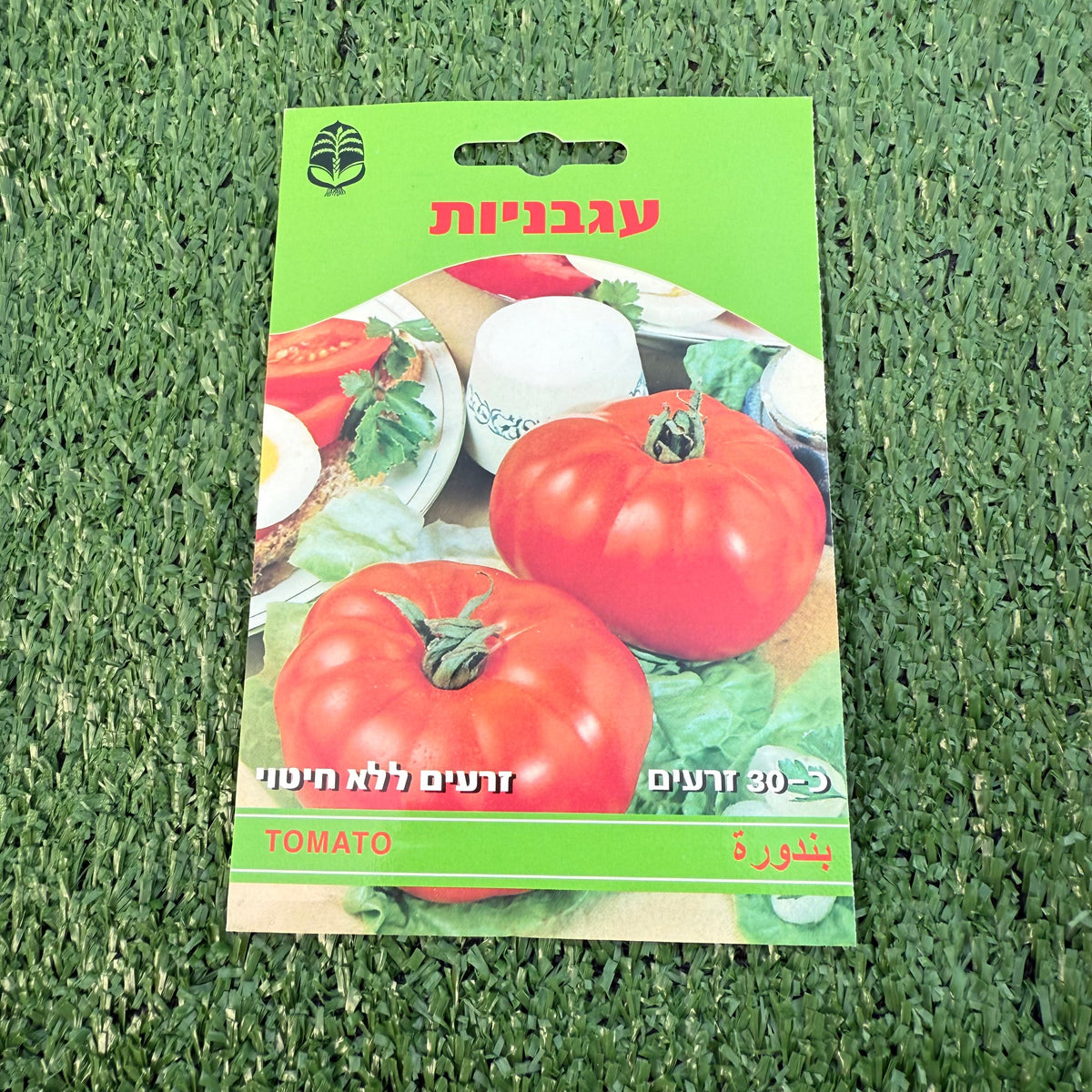 חפיסת זרעי עגבניות ברקע של דשא סינטטי ירוק