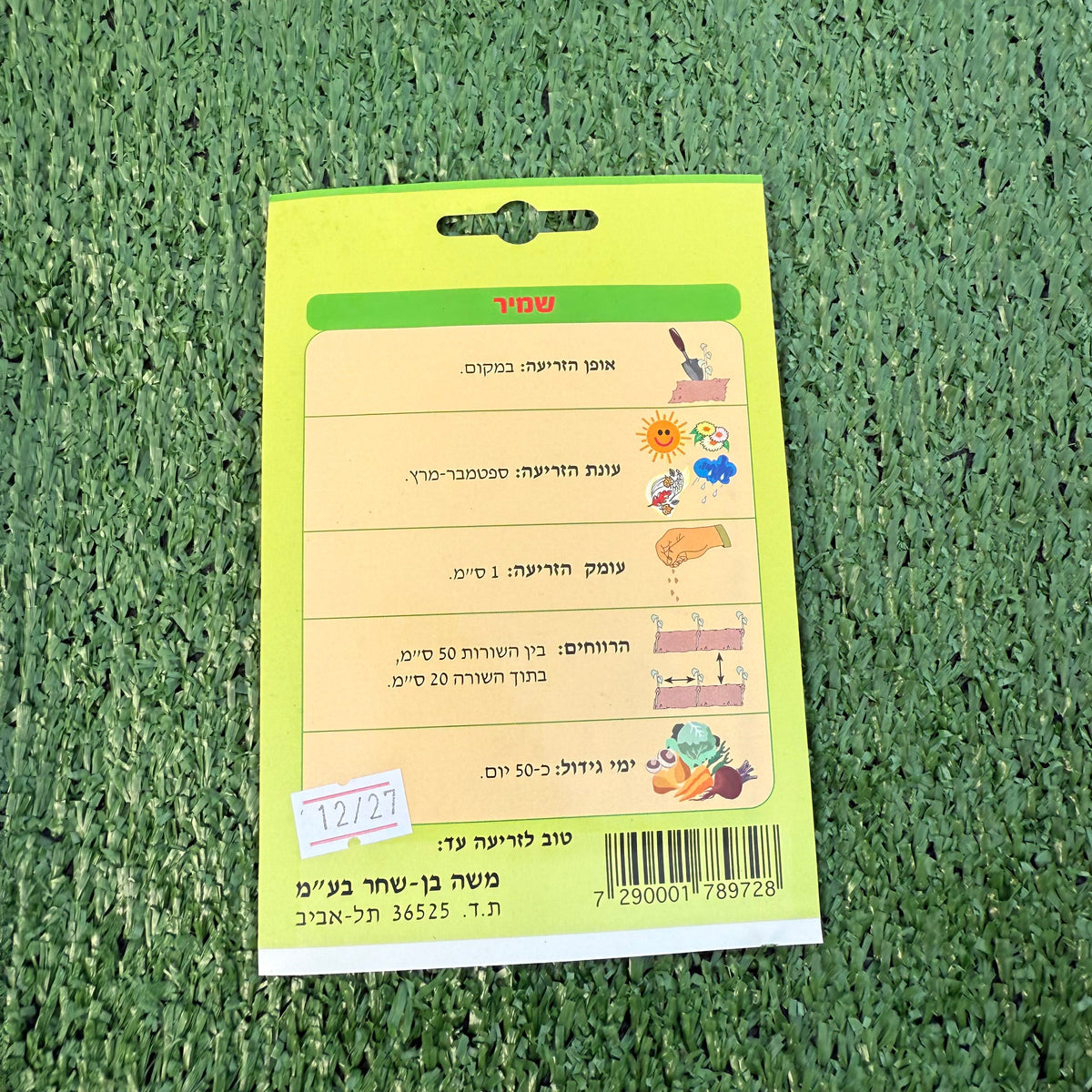 הוראות שימוש של חפיסת זרעי שמיר ברקע של דשא סינטטי ירוק