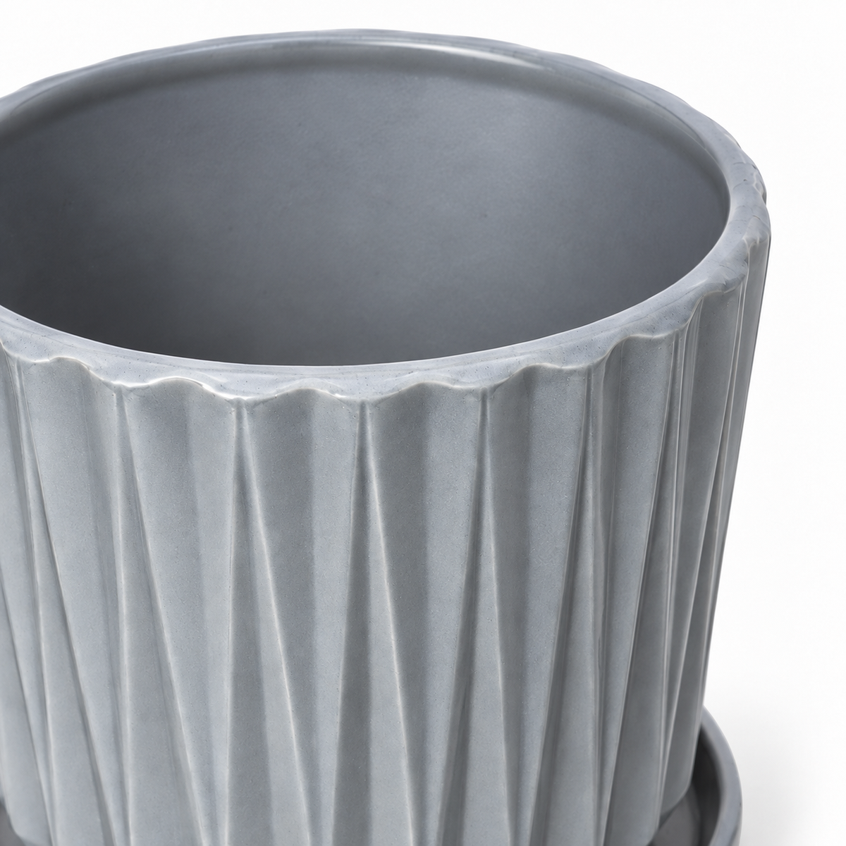 Close view of the rim, interior, and fluted ceramic surface of the large gray inverse diamond planter on white